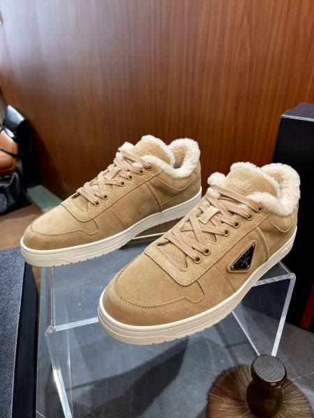 PRADA suede sneakers with shearling lining, sizes 38-45. Features warm fabric, lightweight rubber sole with embossed logo, and enamel triangle metal emblem.