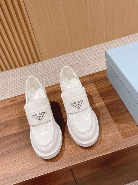 Prada high-top loafers with classic triangle logo. Wide design, chunky heel, comfortable one-piece sole. Increases height by 7.5cm. Imported calfskin upper, lambskin lining. Sizes 35-40.
