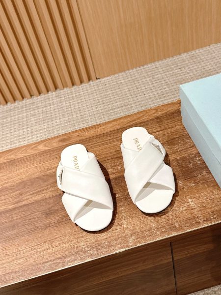 Prada 2025 SS flat sandals with cross design and triangle logo. Made from lambskin with rubber sole. Sizes 35-39.