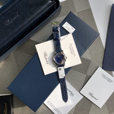 Chopard Happy Diamonds series features iconic moving diamonds, a 36mm steel case, silver dial, and 100% alligator strap. Elegant and fashionable for women.