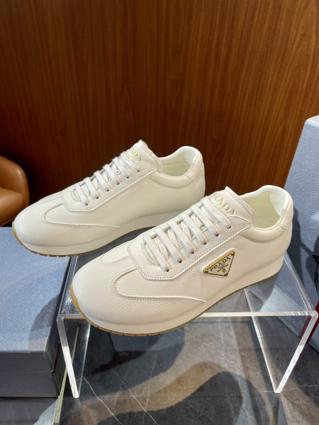 PRADA men's leather sneakers in sizes 39-44. Crafted from cowhide with a lightweight sole, featuring enamel triangle logo and screen-printed tongue tag.