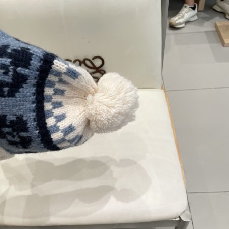 Original Moncler Nordic-style bobble hat with ear flaps and braided pattern.